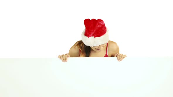 Beauty brunette in santa hat showing white poster