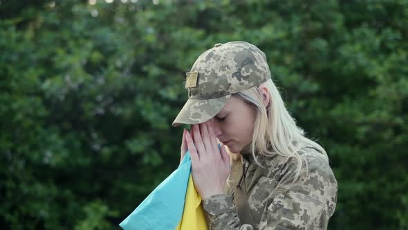 Female Patriot Soldier Holds Ukrainian Flag and Praying with Hope