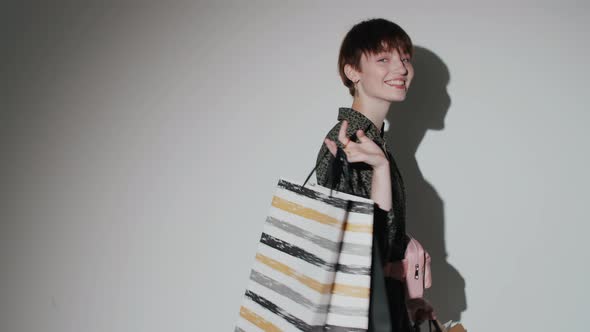 Beautiful Girl Posing with Shopping Bags in Studio