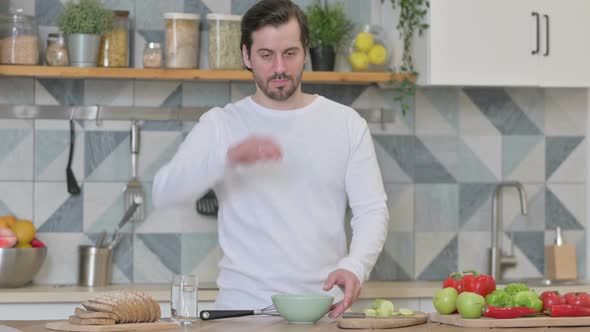 Healthy Young Man Feeling Tired While Cooking in Kitchen