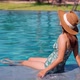 Young woman traveler relaxing and enjoying by a tropical resort pool - VideoHive Item for Sale