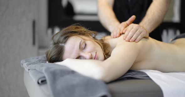 Woman Getting a Deep Back Massage at Spa Salon
