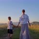 mom and son walk hand in hand across the field - VideoHive Item for Sale