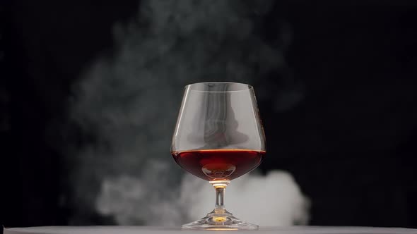 Strong Alcoholic Drink Whiskey Brandy Cognac in Glass with Smoke From Cigar