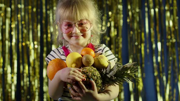 Trendy Girl in Pink Sunglasses Posing Looking at Camera with Bunch of Fruits in Hands in Night Club