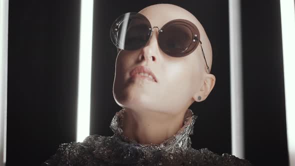 Hairless Woman in Sunglasses and Foil Wear Posing in Studio