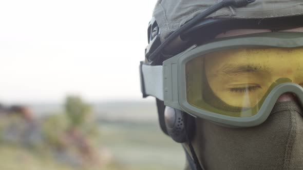 Half of the Face with the Opening Eyes of a Military Man in a Yellow Mask Closeup on Background of