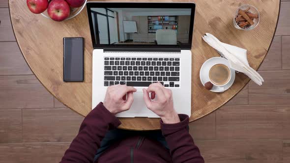 Man Watches Videos at His Laptop in a Coffee Shop