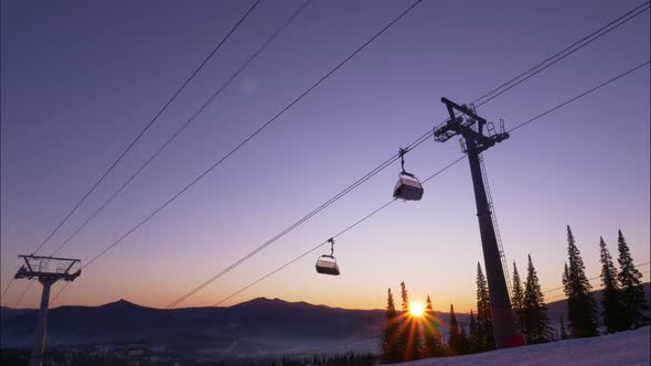 Ski Lift with Moving Cabins Above Snowy Mountain Slope