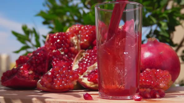 Freshly Squeezed Pomegranate Juice Wave is Flowing Into Glass Jug in Slow Motion