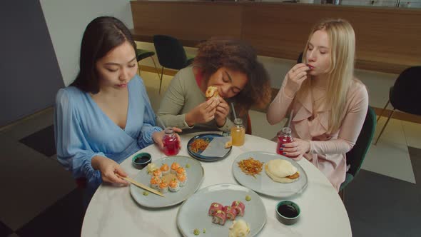 Positive Multiracial Females Enjoying Meal at Restaurant