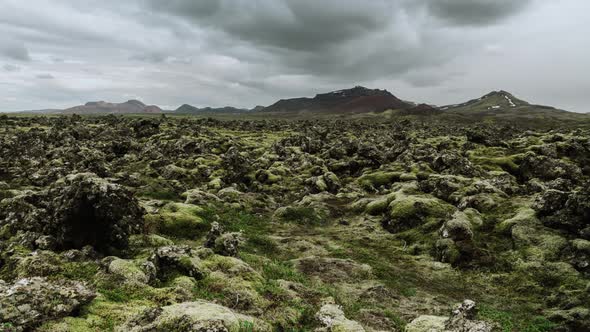 Lava Field With Volcano On Horizon And Motion Clouds In The Sky In Iceland