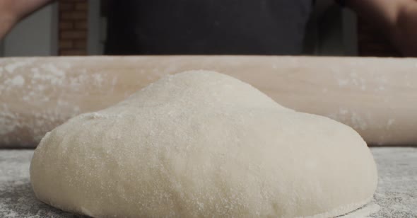 Anonymous chef rolling dough for pastry