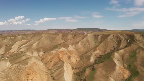 Rolling mountains under blue sky and white clouds