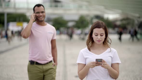 Front View of Peaceful Young Woman Texting During Stroll