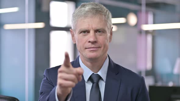 Portrait of Middle Aged Businessman Pointing Finger and Inviting