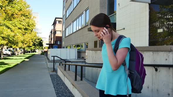 Teenager in downtown Denver talks on her cellphone and then hangs up