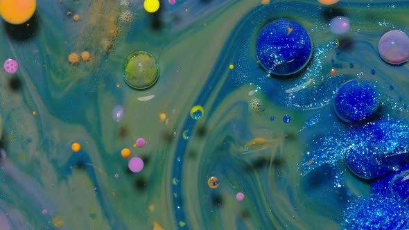 Top View Movement of Blue Oil Ink Drops Bubbles Multicolored Artistic Paint Surface Background