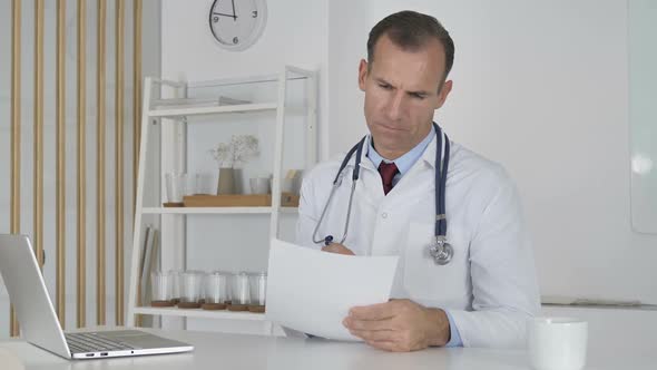 Doctor Reading Documents in Clinic Paperwork