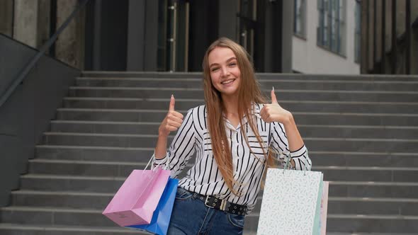 Stylish Girl Holding Shopping Bags and Showing Thumbs Up. Rejoicing with Good Holiday Sale Discounts