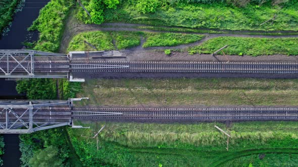 Metal Structure Railway Bridge Over a Small River and the Trees of a Forest