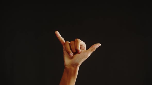 African American Man Showing Hawaiian Shaka Greeting Gesture with Fingers Isolated on Black