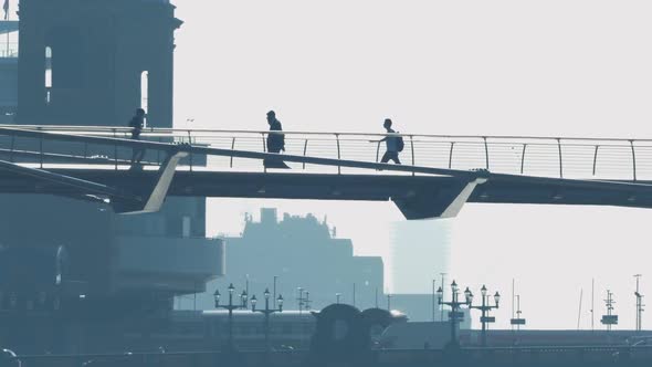 People On Footbridge With Train And Cars In The Background