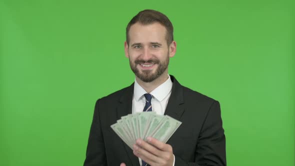 Businessman Putting Money in Pocket with Thumbs UP Against Chroma Key