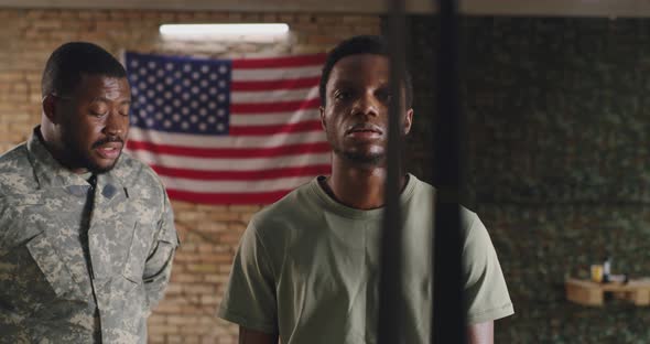 African American Trainer Instructing Soldier During Suspension Training