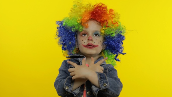 Little Child Girl Clown in Colorful Wig Making Silly Faces, Having Fun, Smiling, Dancing, Halloween