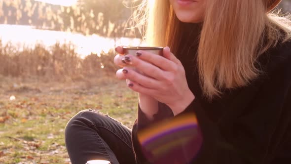 Slow Motion Caucasian Blonde Woman with Beige Hat in Black Sweater Drinks Hot Tea From Thermos in