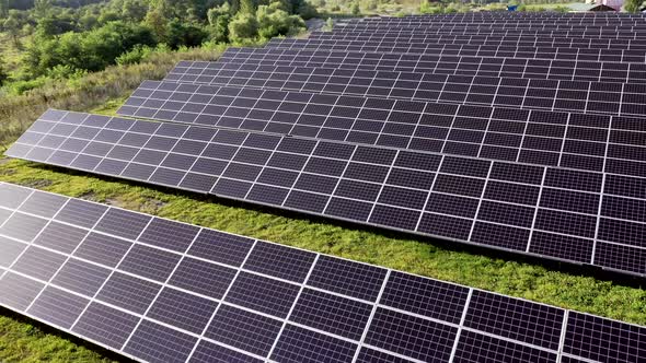 Aerial Top view on Solar Power Station in Green Field on Sunny day.