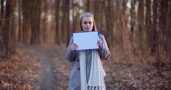 Woman Holding Blank Paper in Front of Camera