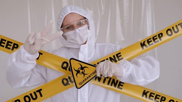 A Doctor in a Medical Suit in the Hospital with a Warning Sign QUARANTINE