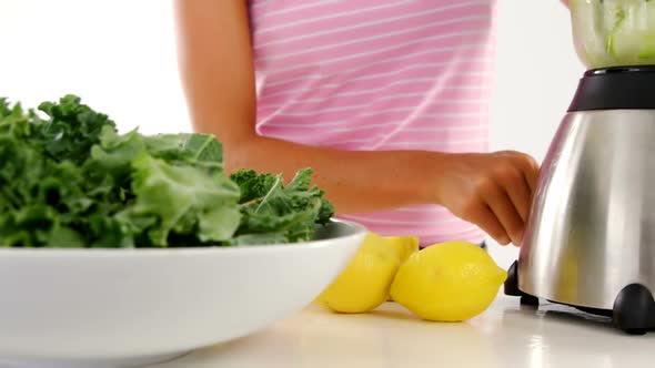 Woman preparing vegetable smoothie