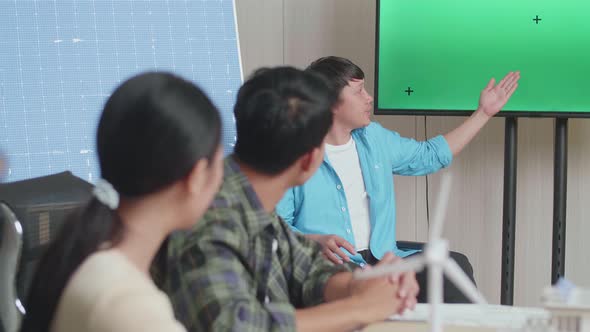 Asian Man Engineer In Wheelchair With Solar Cell Presenting About The Green Screen Tv At The Office