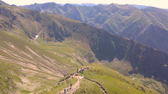 Hikers make it to the top of a mountain and are rewarded with stunning view of rugged landscape, mou