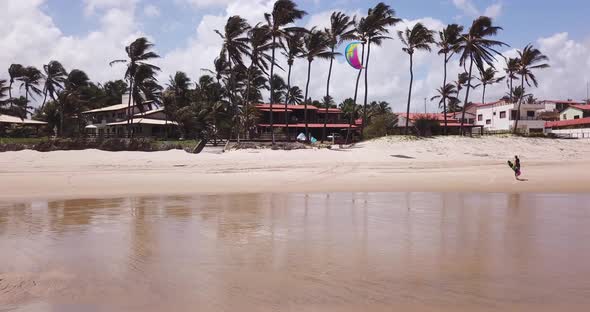 Aerial drone view of a woman walking after kiteboarding on a kite board.