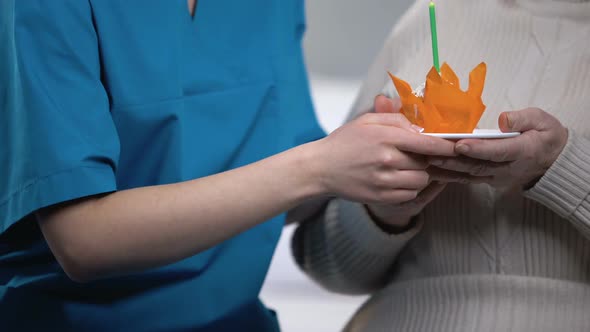 Nurse Presenting Old Patient Birthday Cake, Congratulations and Support, Closeup