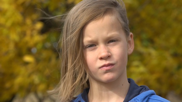 Closeup portrait of a serious adorable little girl. Slow motion