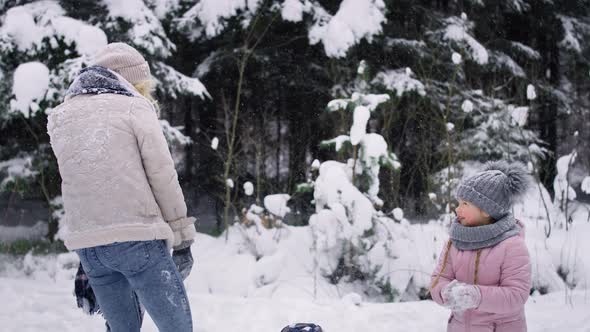 Video of mother and two children having snowball fight. Shot with RED helium camera in 8K.