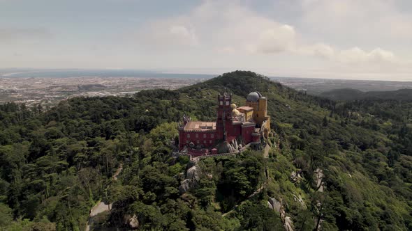 Aerial orbiting shot around Pena palace, the famous historic attraction on Sintra hills, Portugal.