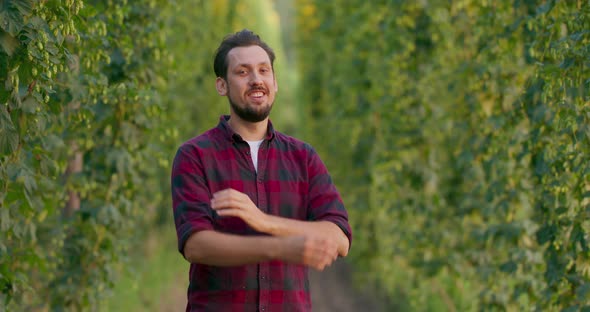 A Portrait of a Farmer Folding His Arms While Standing in the Hop Field