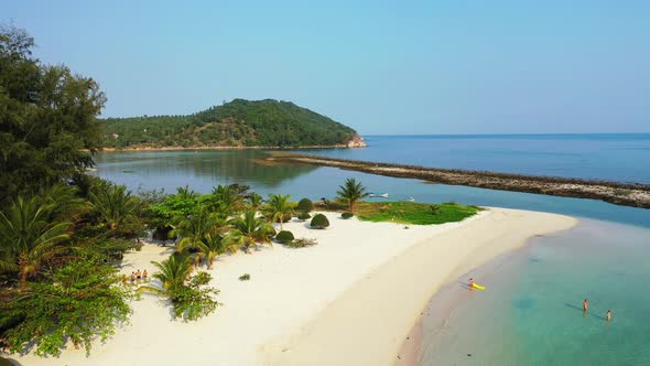 Wide angle birds eye tourism shot of a white sand paradise beach and aqua turquoise water background