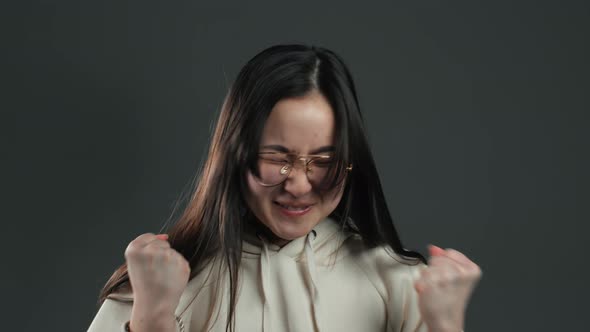 Asian Girl with Long Hair Very Glad and Happy, She Shows Yes Gesture of Victory