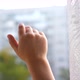 The Child Stands at the Window and Waving His Hands - VideoHive Item for Sale