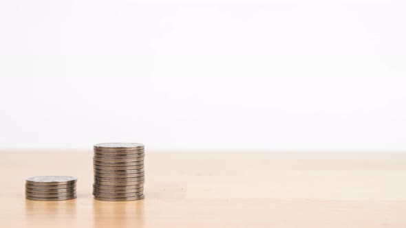 Stop motion animation Raising of coins stacks on wooden desk