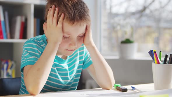 Boy is Doing  Homework at the Table. Cute Child is Learning at Home.