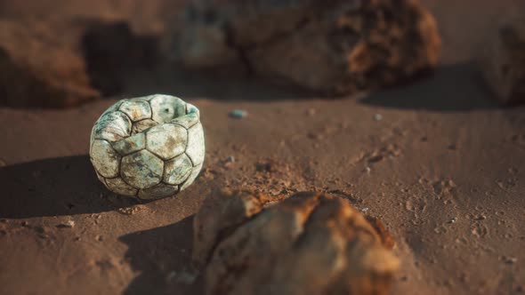 Old Football Ball on the Sand Beach