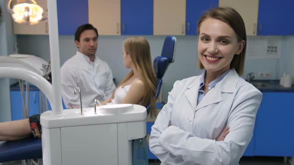 Pretty Female Dentist Smiling with Arms Crossed